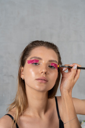 Kopfschuss einer jungen frau beim augen-make-up