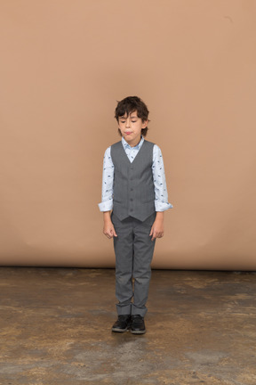 Vista frontal de un chico lindo en traje gris