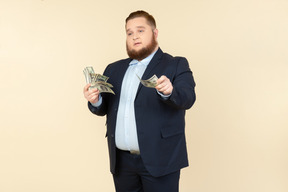 A plus-size man in a black costume with dollar bills in his hands