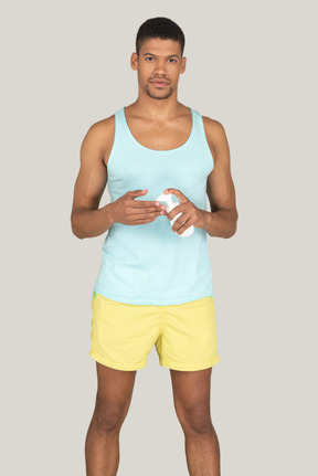 A man in a blue tank top and yellow shorts