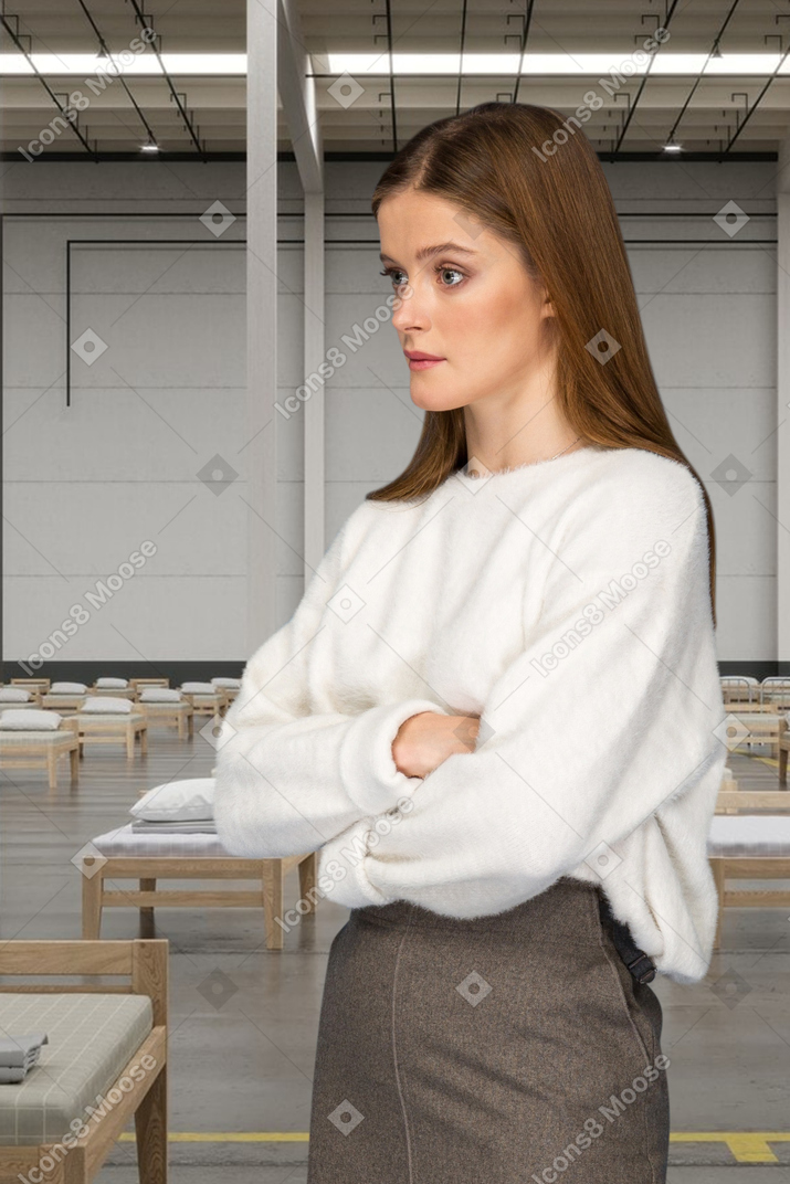 A woman witn arms crossed standing in a hospital toom