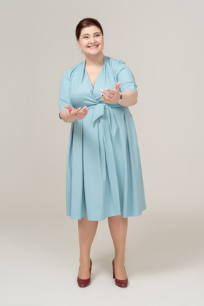 Front view of a woman in blue dress greeting someone
