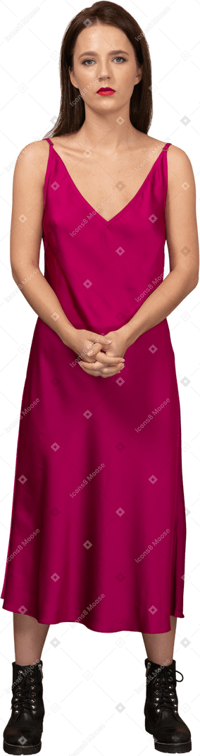Vue de face d'une jeune femme en belle robe rouge regardant la caméra