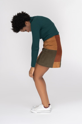 African-american teenager bending over making rounded back