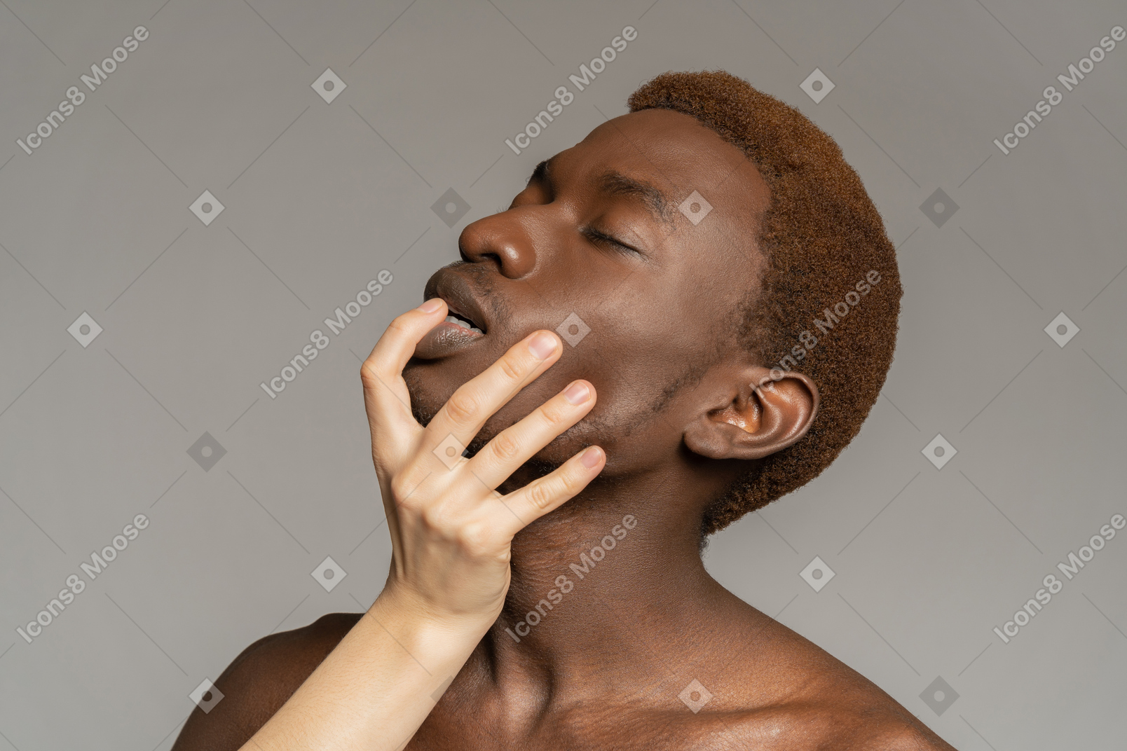 黒人の若い男の顔に触れる白い手