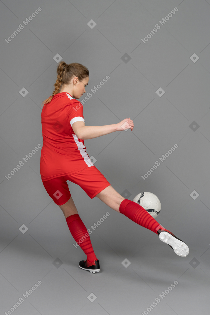 A female football player is about to hit the ball