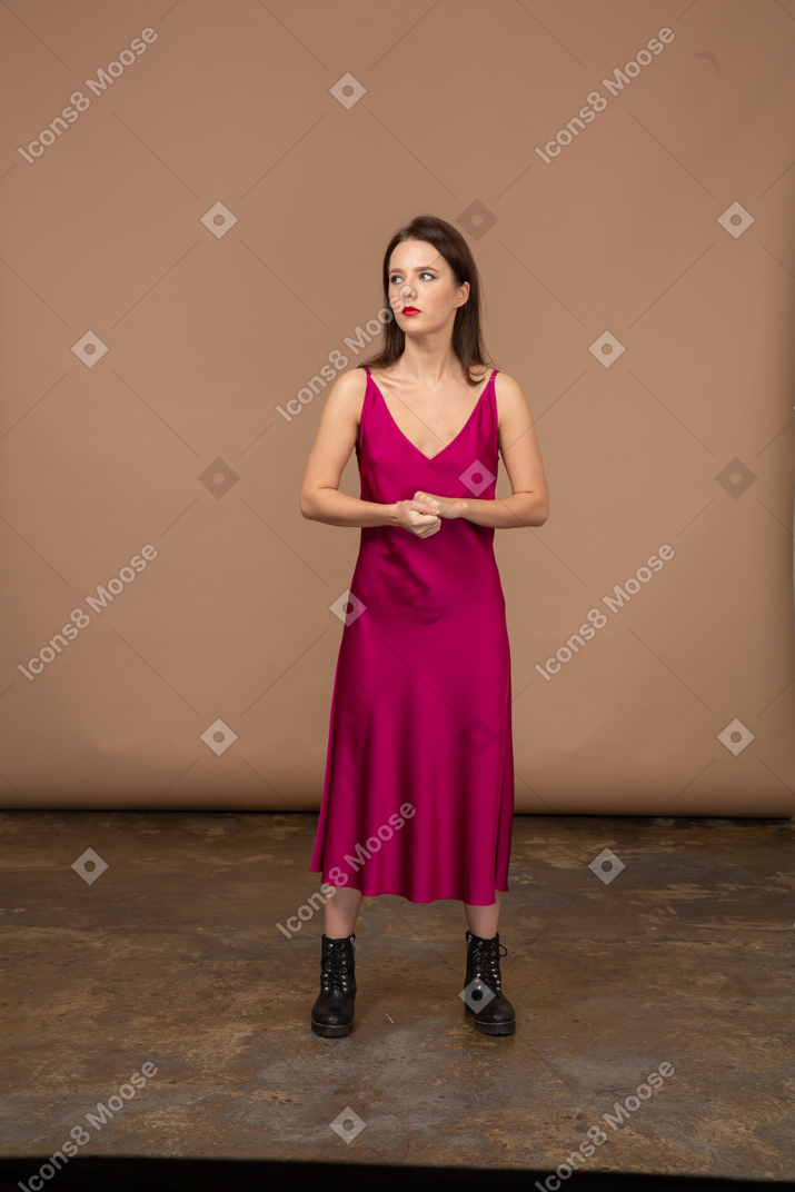 Vista frontale di una bellissima giovane donna in abito rosso che guarda in alto
