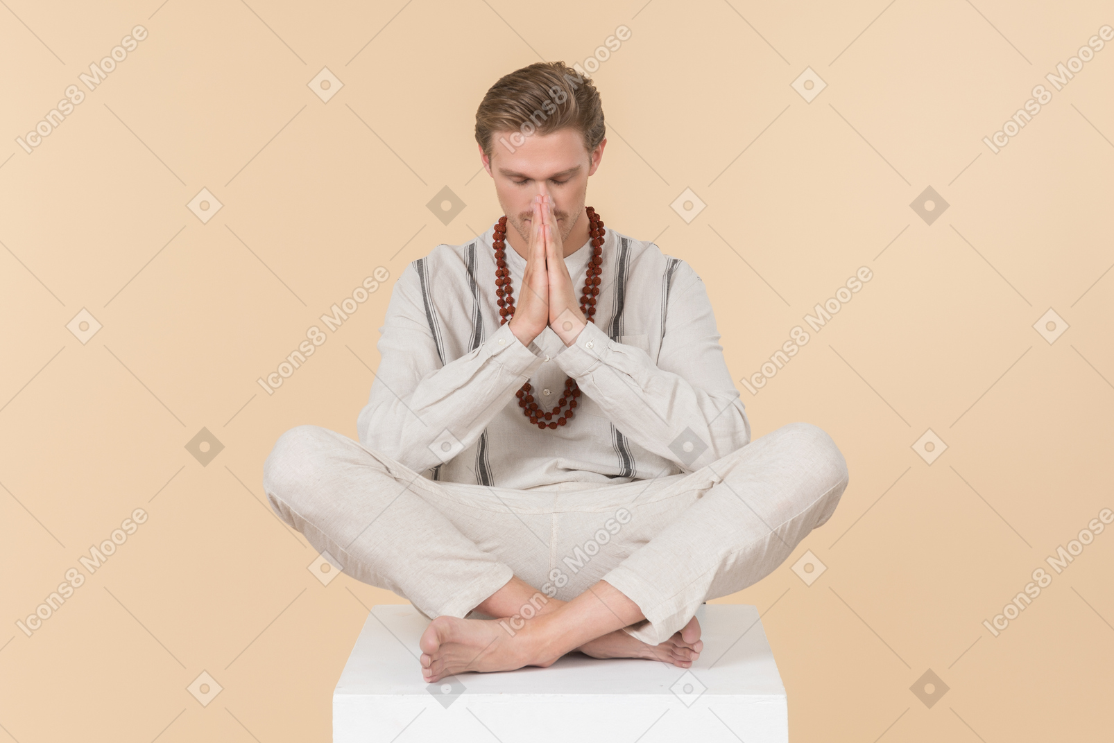 Young man sitting in lotus pose with his eyes closed