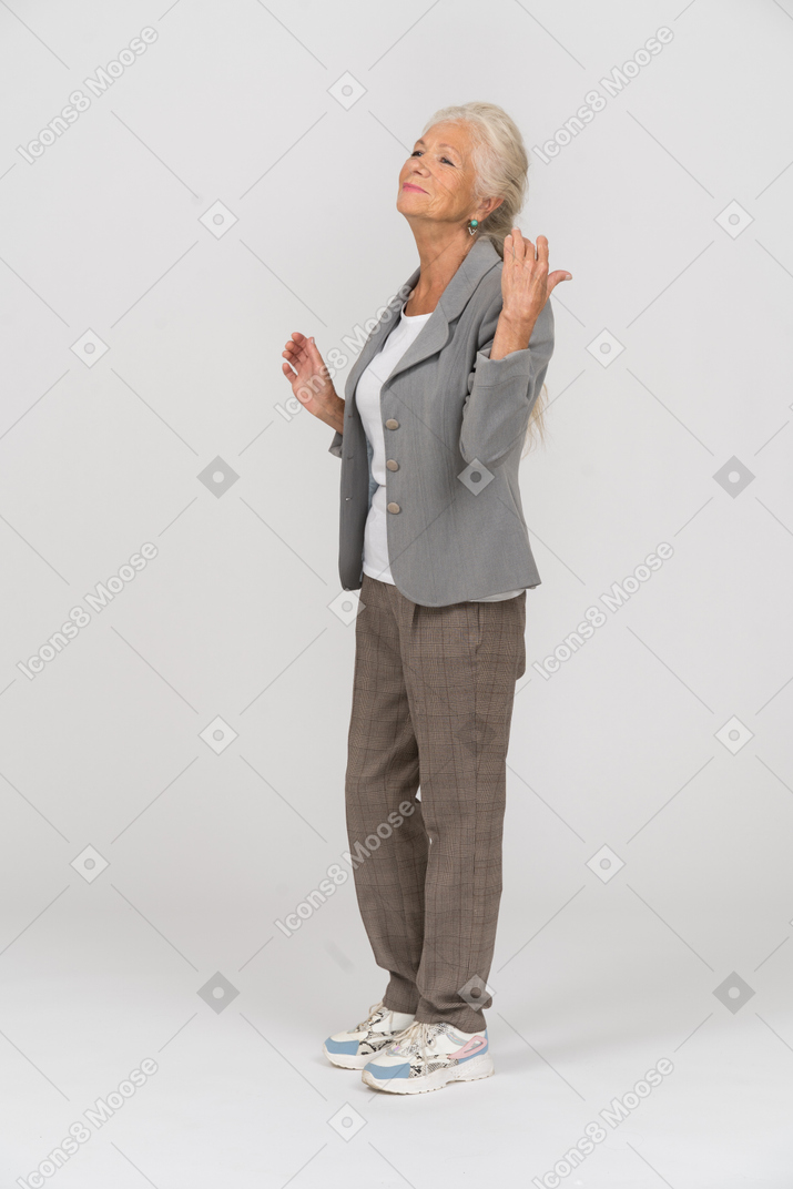 身振りで示すスーツで幸せな老婦人の側面図