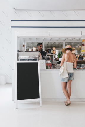 Mujer de pie en la caja registradora en café