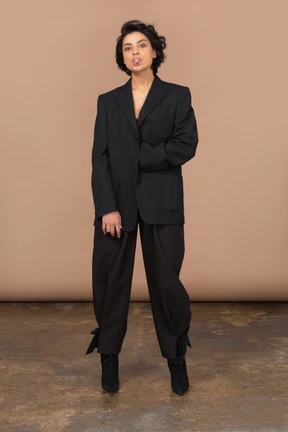 Front view of a female businesswoman in a black suit showing tongue and looking at camera