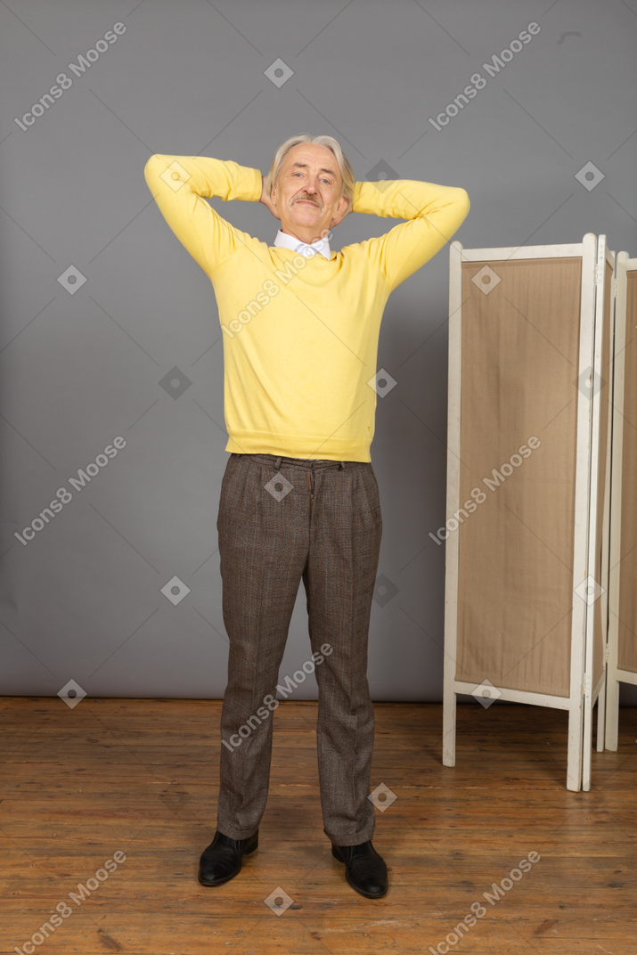 Front view of a resting old man putting hands behind head