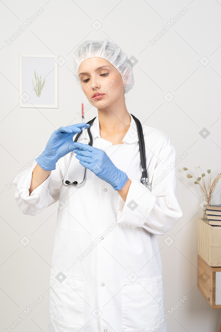 拿着注射器的一位年轻女性医生的正面图