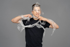 Young man wrapping plastic around him