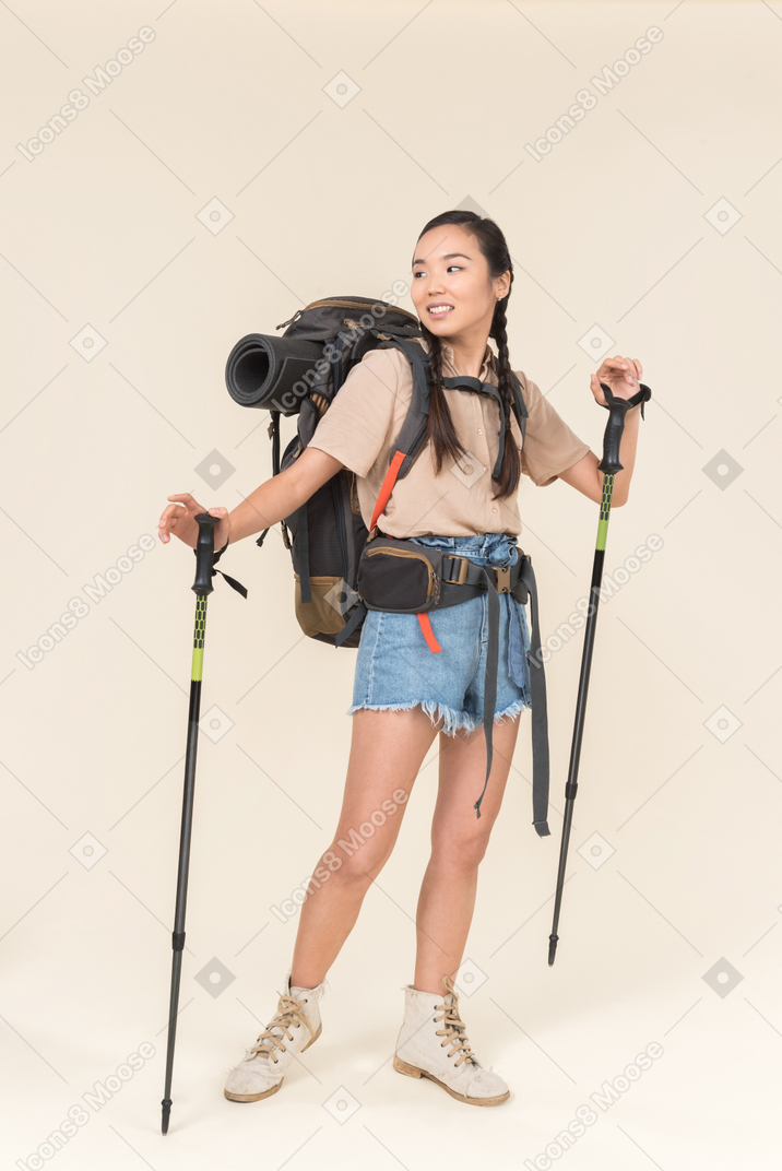 Donna giovane escursionista a piedi con bastoncini da trekking
