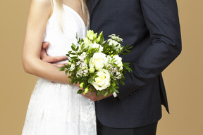 Sposa e sposo in possesso di un bouquet da sposa