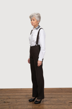 Трехчетвертный вид недовольной пожилой женщины, одетой в офисную одежду