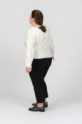 Mujer regordeta en suéter blanco de pie