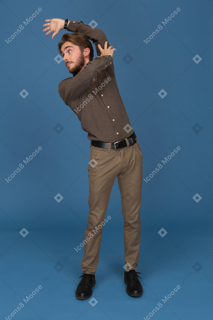 A slim young man is posing in a strange way