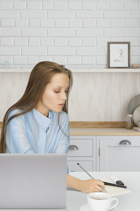 A woman sitting at a table working on a laptop