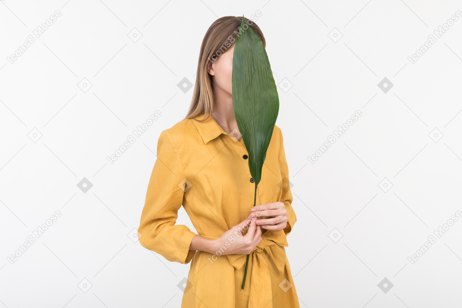Young woman closing face with green leaf