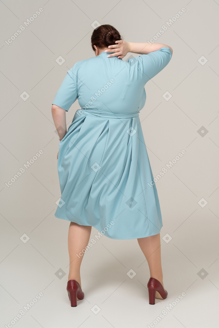 一个穿着蓝色连衣裙跳舞的女人的后视图