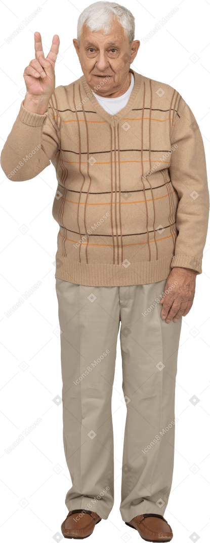 Vista frontale di un uomo anziano in abiti casual che mostra il segno v