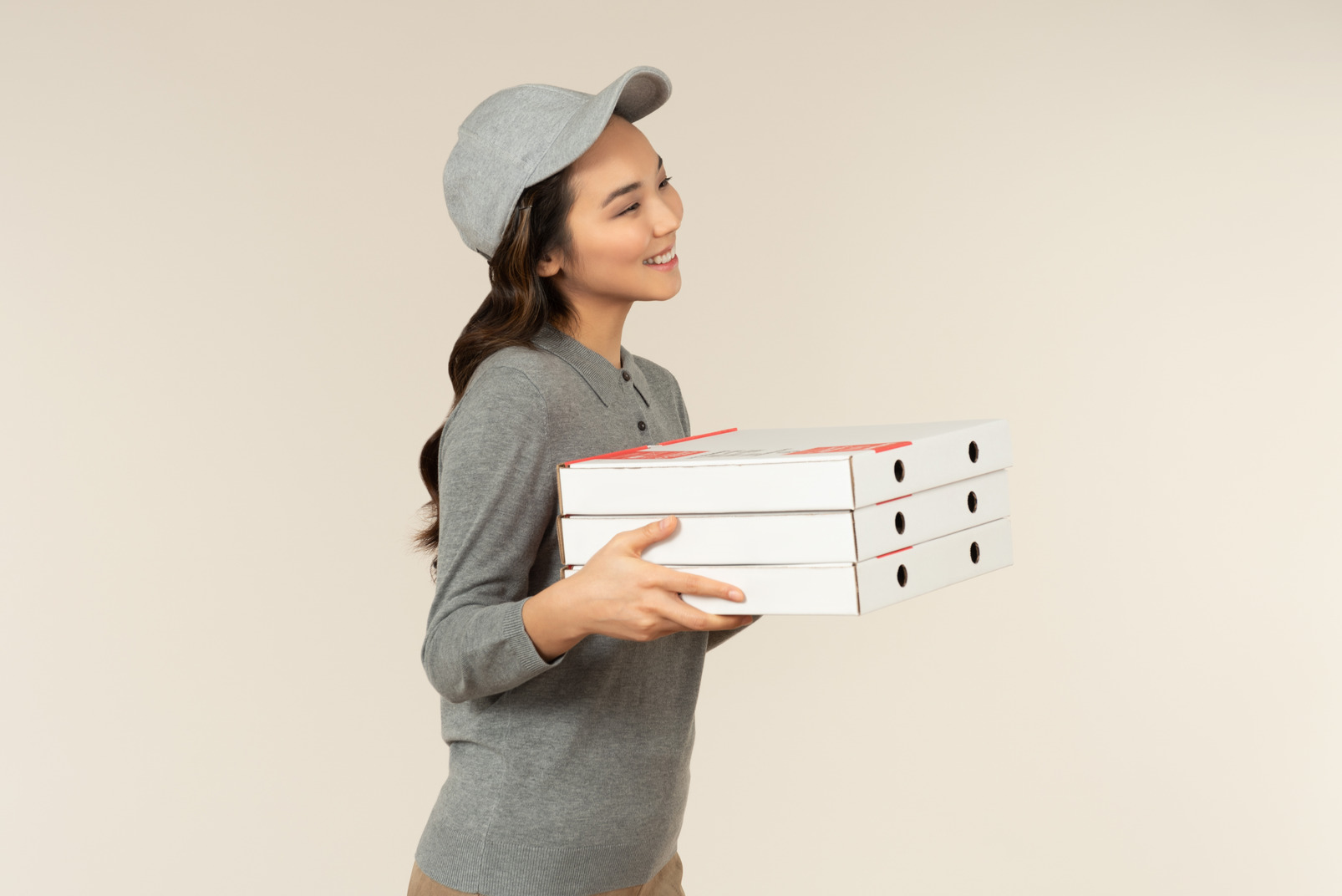 Young asian pizza delivery girl holding pizza boxes