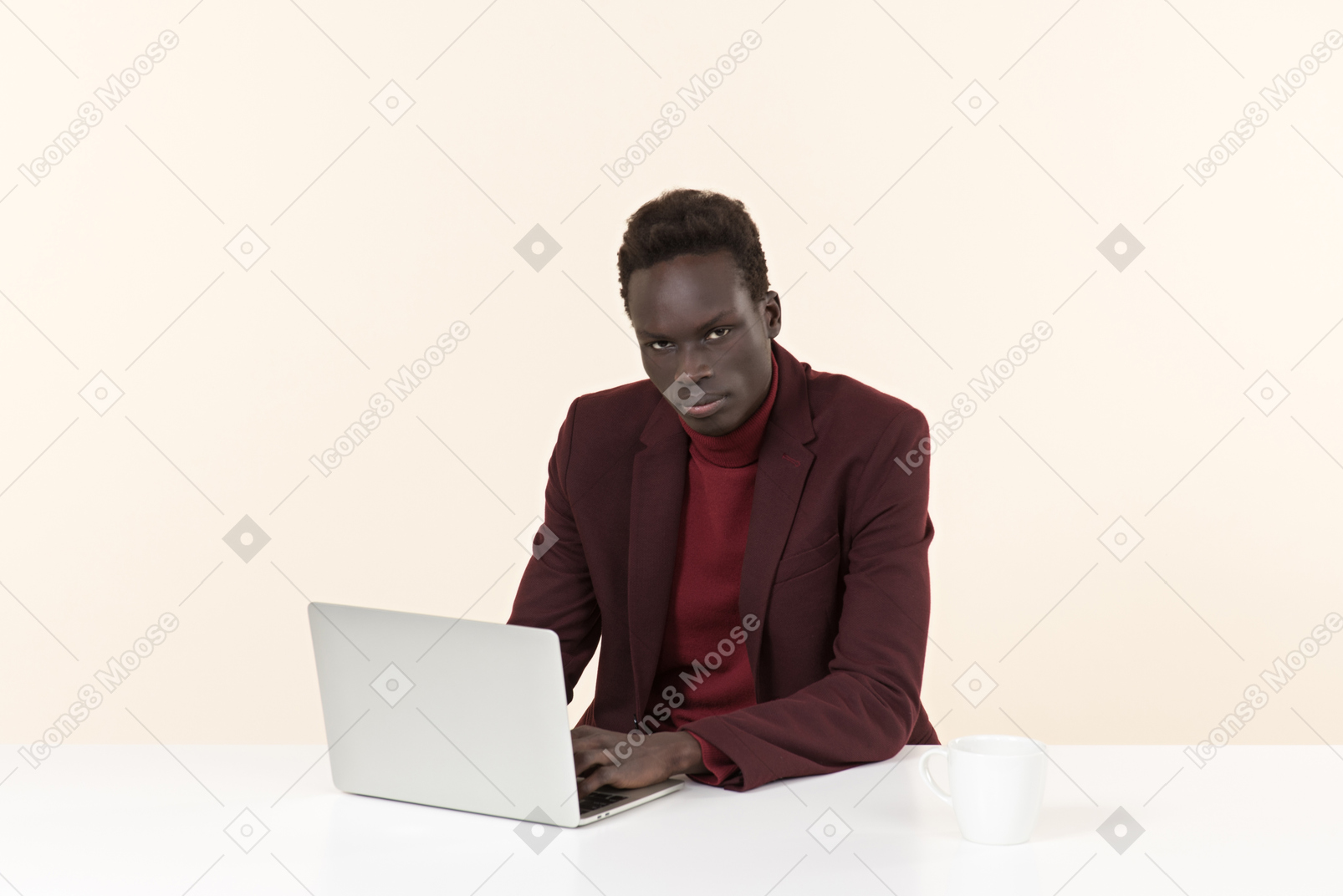 Элегантный темнокожий мужчина сидит за столом в офисе