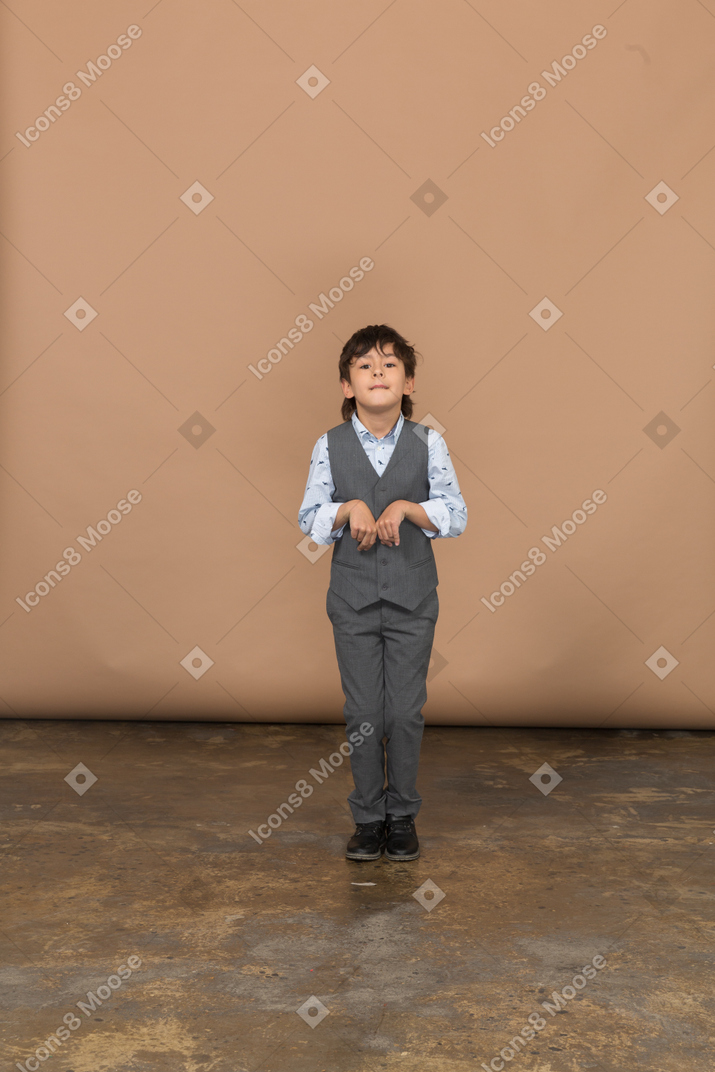 Front view of a cute boy in grey suit looking at camera