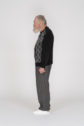 An old man standing sideways