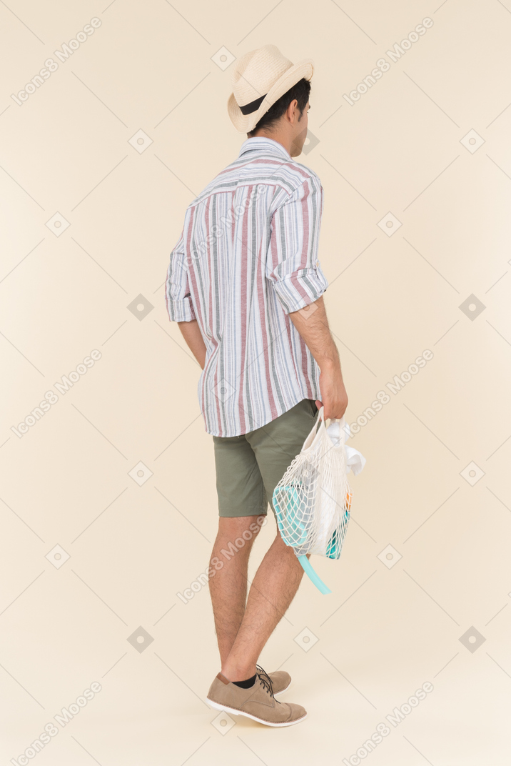Man standing half sideways and holding avoska