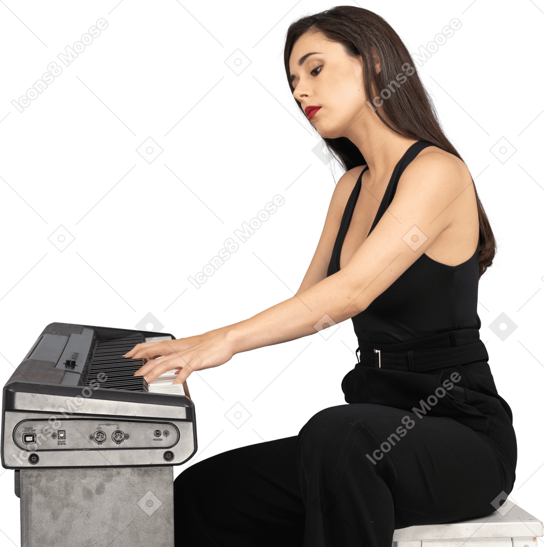 一位年轻的女士，穿着黑色西装，坐着弹钢琴的侧视图