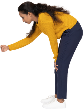 Side view of a girl in casual clothes bending down with extended arm
