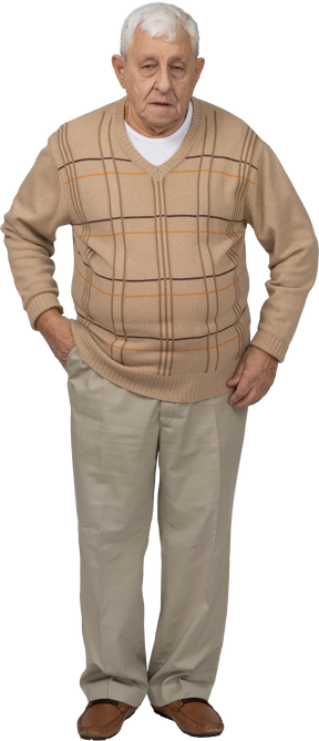 Front view of an old man in casual clothes posing with hand in pocket