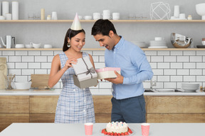 A woman opening gifts from a man on her birthday