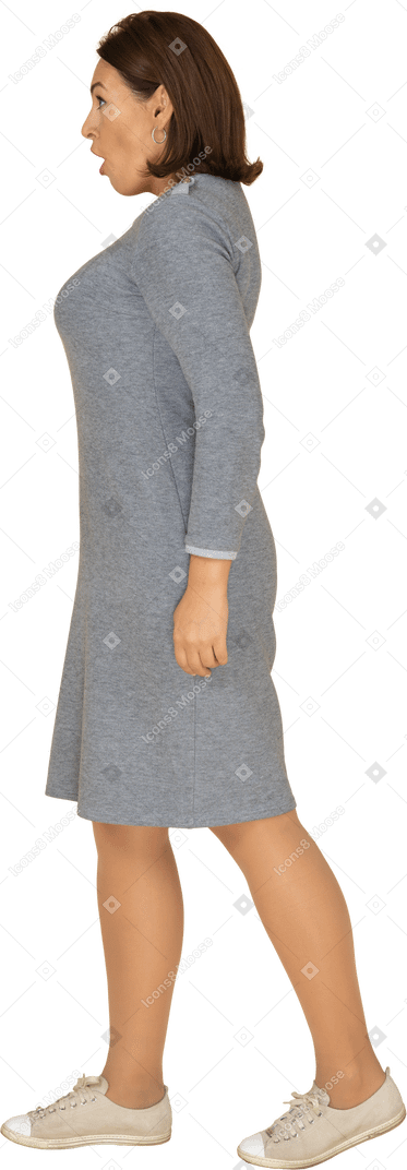 Vista laterale di una donna impressionata in abito grigio