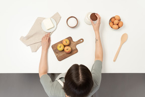 Um padeiro feminino preparando ingredientes de panificação