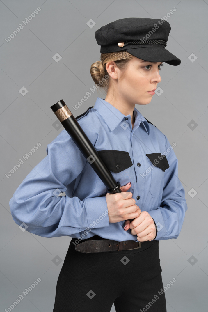 Guardia de seguridad femenina seria con un bastón
