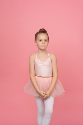 Mignonne petite fille debout avec ses mains jointes