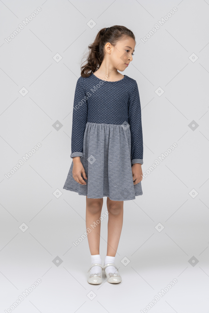 Vista frontal de una niña de pie con la cabeza vuelta