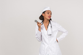 Привлекательная молодая женщина-врач держит стетоскоп
