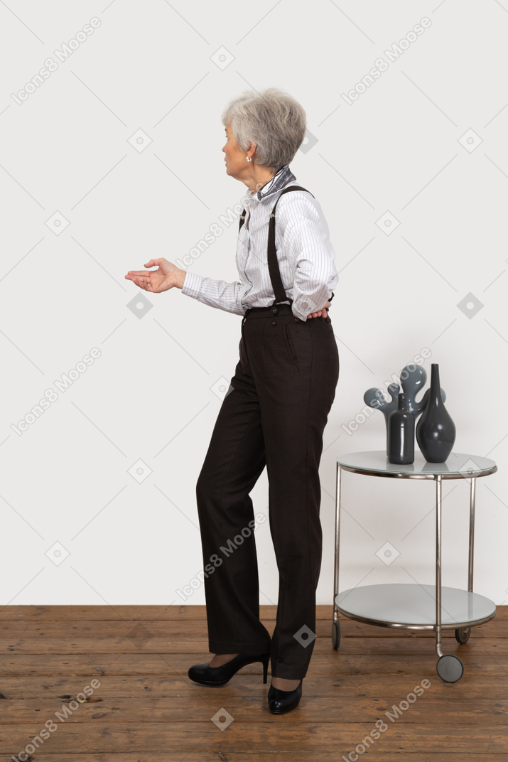 Side view of a questioning old lady in office clothing looking aside