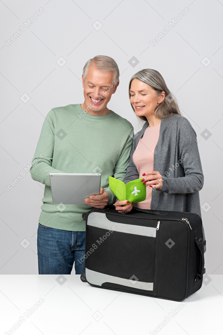 Middle aged couple checking travel info on tablet