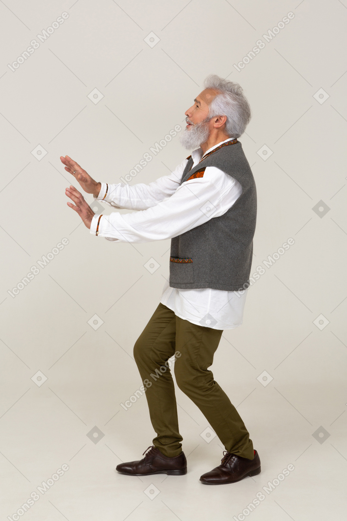 Vista lateral de um homem em roupas casuais, levantando as mãos