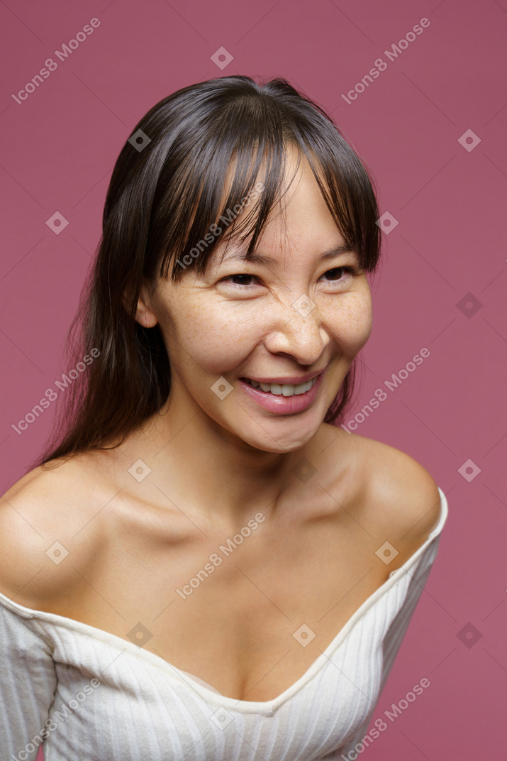 Vue de trois quarts d'une femme d'âge moyen souriant et regardant de côté