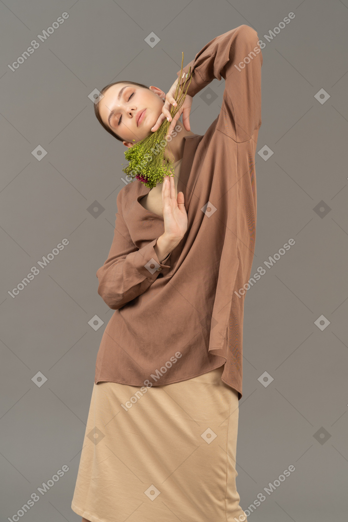 Young woman with eyes closed posing with flowers