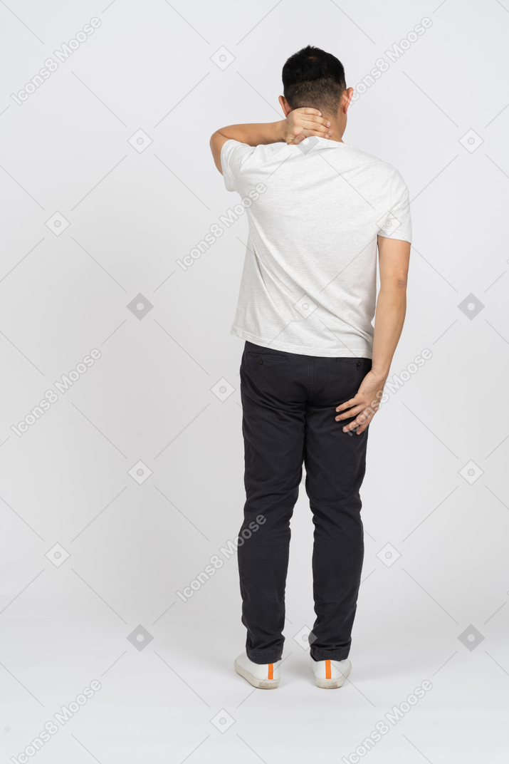 Vista traseira de um homem em roupas casuais, sofrendo de dor no pescoço