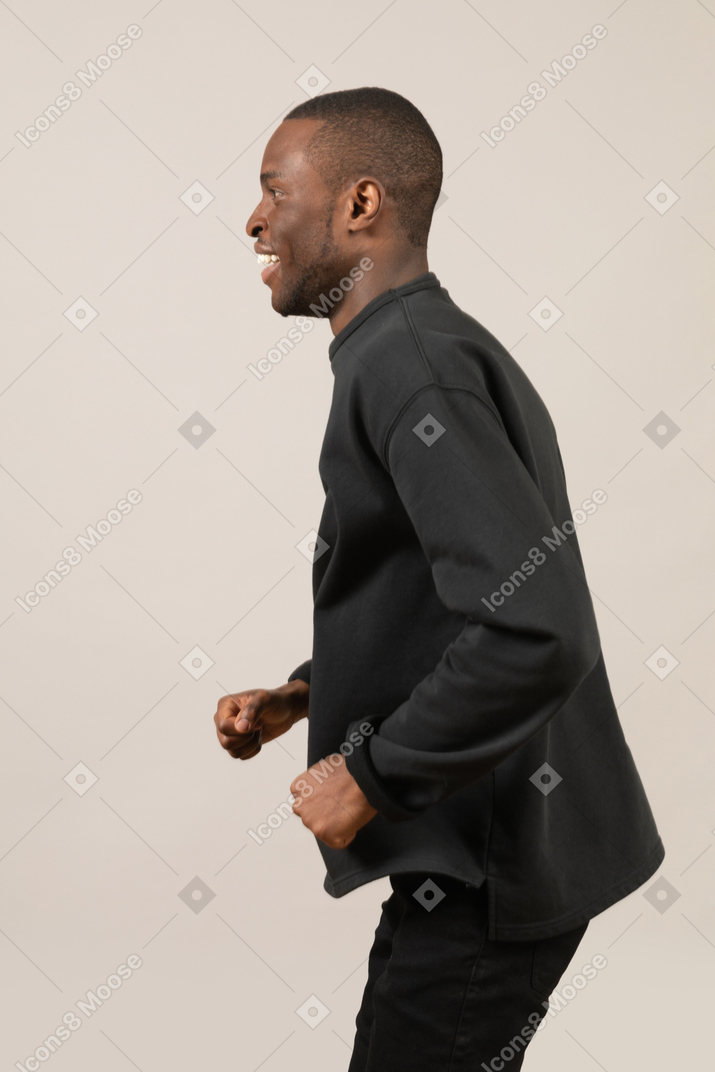 Side view of happy young man running