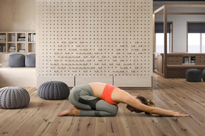 A woman in a yoga position on a wooden floor